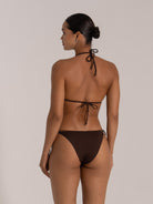 Woman wearing dark brown triangle bikini, back tie halter top and minimal coverage bottom – beachwear style
