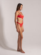 Side view of red one-piece swimsuit with ring cutout detail