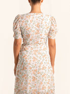 Back view of floral wrap dress with puff sleeves and tie waist