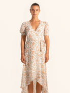 Front view of floral wrap dress with asymmetrical hemline and short sleeves