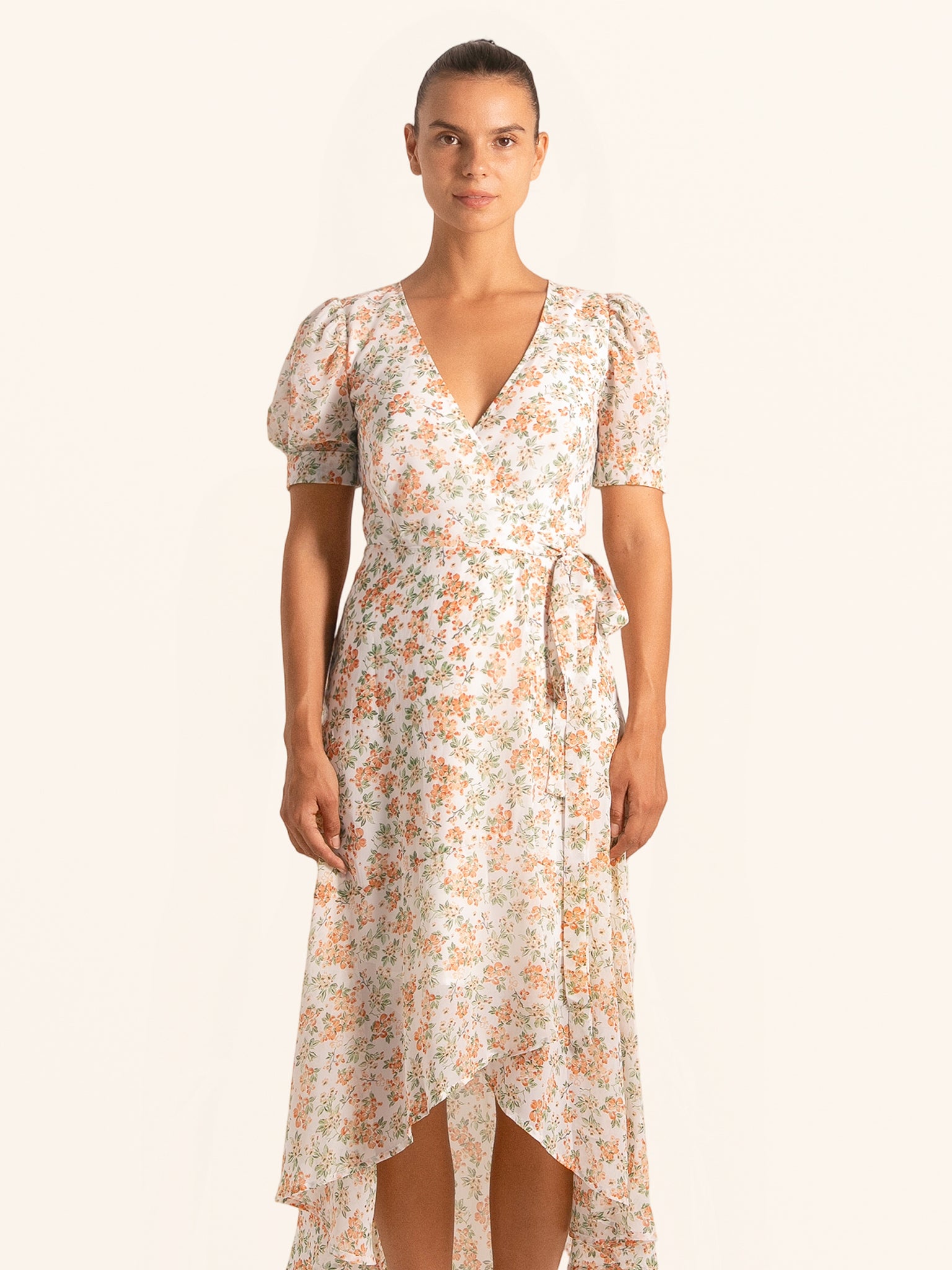 Front view of floral wrap dress with asymmetrical hemline and short sleeves