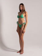 Green triangle bikini set with textured fabric shown from a front-side angle on model.