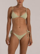 Minimalist green ribbed triangle bikini with thin shoulder straps and adjustable bottom ties, front-facing model.