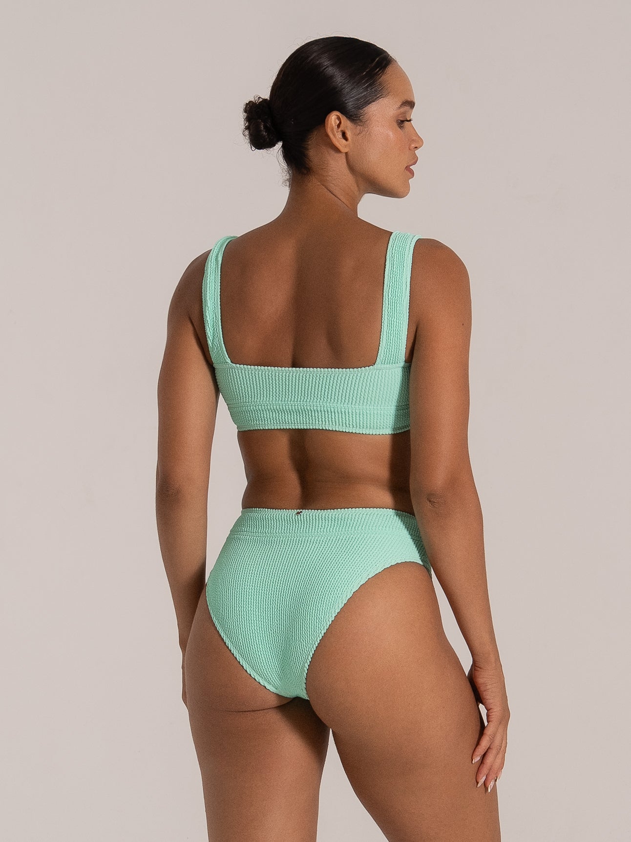 Rear angled shot of green scoop neck bikini top