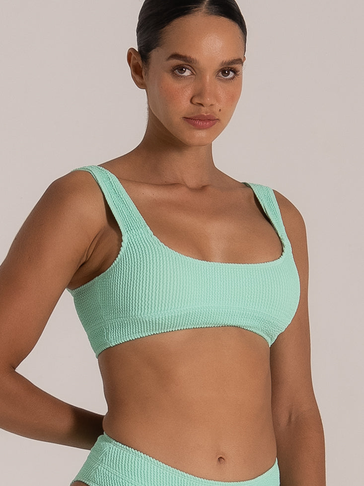 Side view of green textured bikini top showing ribbed fabric details