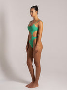 Close-up of a green one-piece with a gold ring accent and textured stretch fabric, perfect for summer beachwear.
