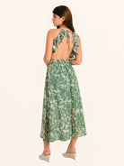 Rear side profile of green floral maxi dress with halter tie back design