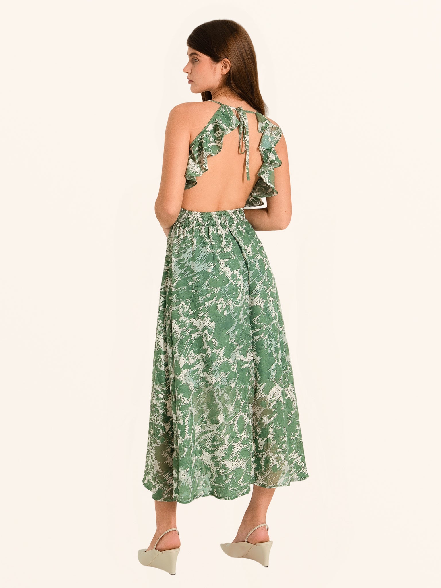 Rear side profile of green floral maxi dress with halter tie back design