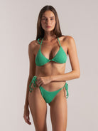 Model wearing green triangle bikini top and side-tie bottom, front facing