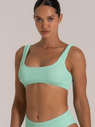 Close-up of green bikini top with scoop neckline and wide shoulder straps