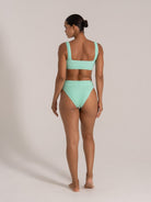 Back view of a mint green textured bikini set with wide straps and high waist bottom.