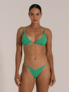 Full front view of woman wearing green triangle bikini top and matching bottom.