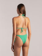 Back view of woman wearing a green textured triangle bikini with halter neck and back tie