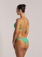 Back angle view of green textured bikini set with mid-rise bottom and sleek beachwear silhouette