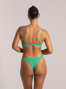 Back view of a woman wearing a green textured V-neck bikini set with cheeky cut and adjustable straps