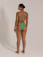 Back view of model in green textured triangle bikini with adjustable straps