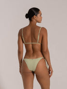 Back view of woman wearing green ribbed triangle bikini set with adjustable straps and side-tie bottoms.