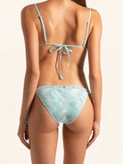 Back view of ice blue tie side bikini bottom with minimal coverage and metallic touch.