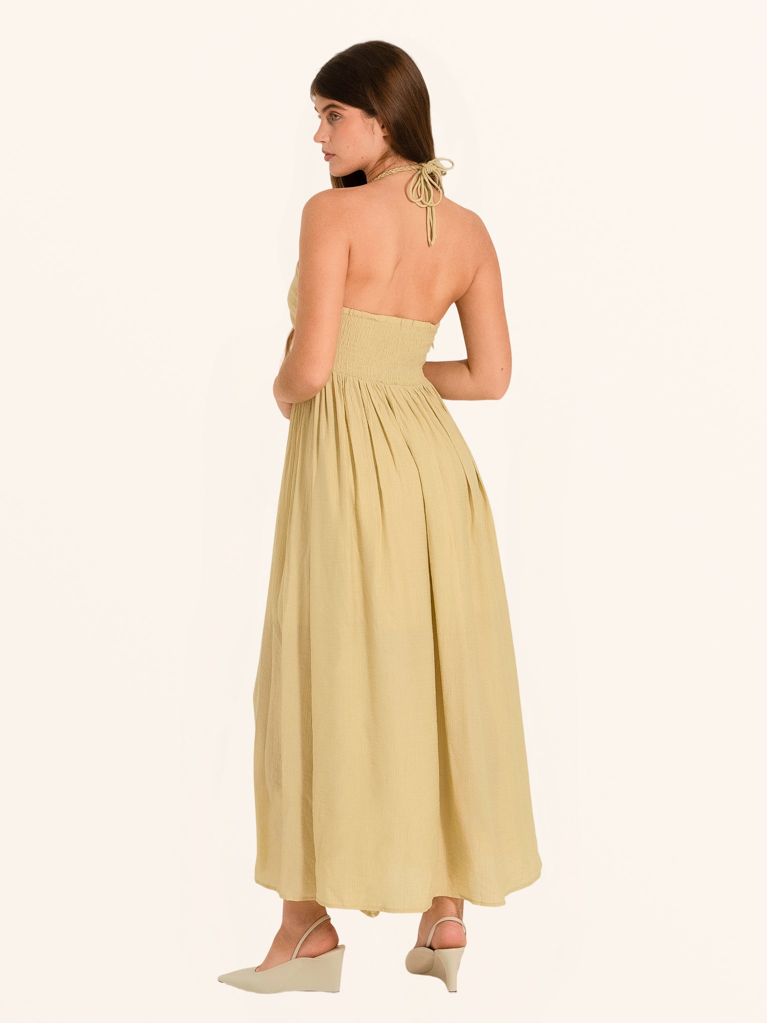 Rear side angle of khaki halter maxi dress with strapless flowing design