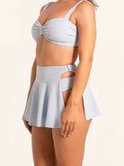 Side angle of light blue bikini skirt set with cutout waist design