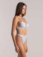 Side profile of model wearing ribbed triangle bikini top in light blue with high waist bottom