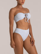 Side view of a model in a light blue embroidered bandeau bikini set with high-waisted coverage.