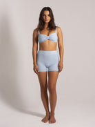 Woman wearing a light blue ribbed bikini top paired with matching high-waisted ribbed shorts