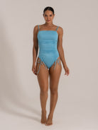 Front view of a light blue ruched one-piece swimsuit with double shoulder straps and a square neckline.