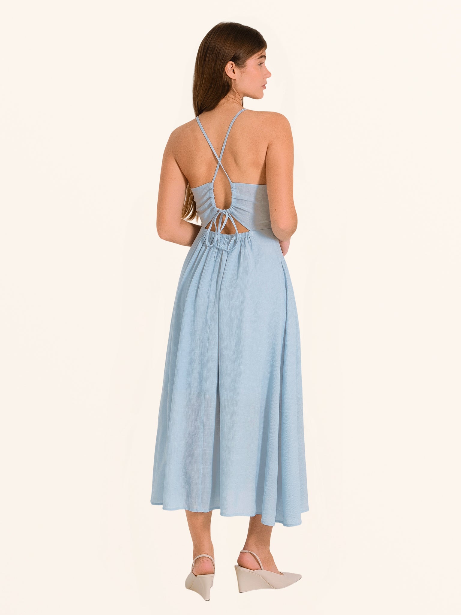 Side profile of light blue spaghetti strap maxi dress with flowing hemline