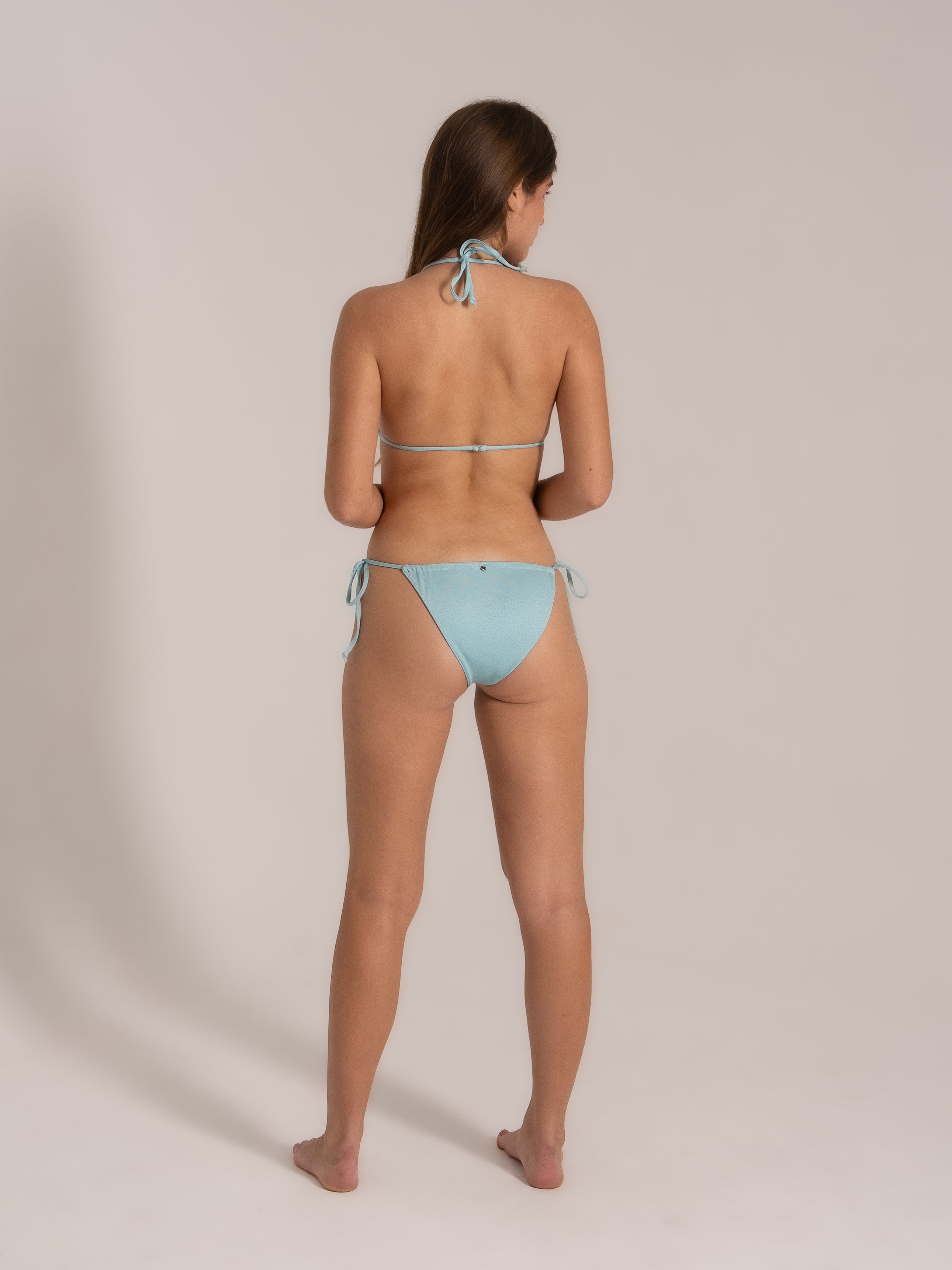 Back view of model wearing a light blue string bikini set, showcasing tie-back details