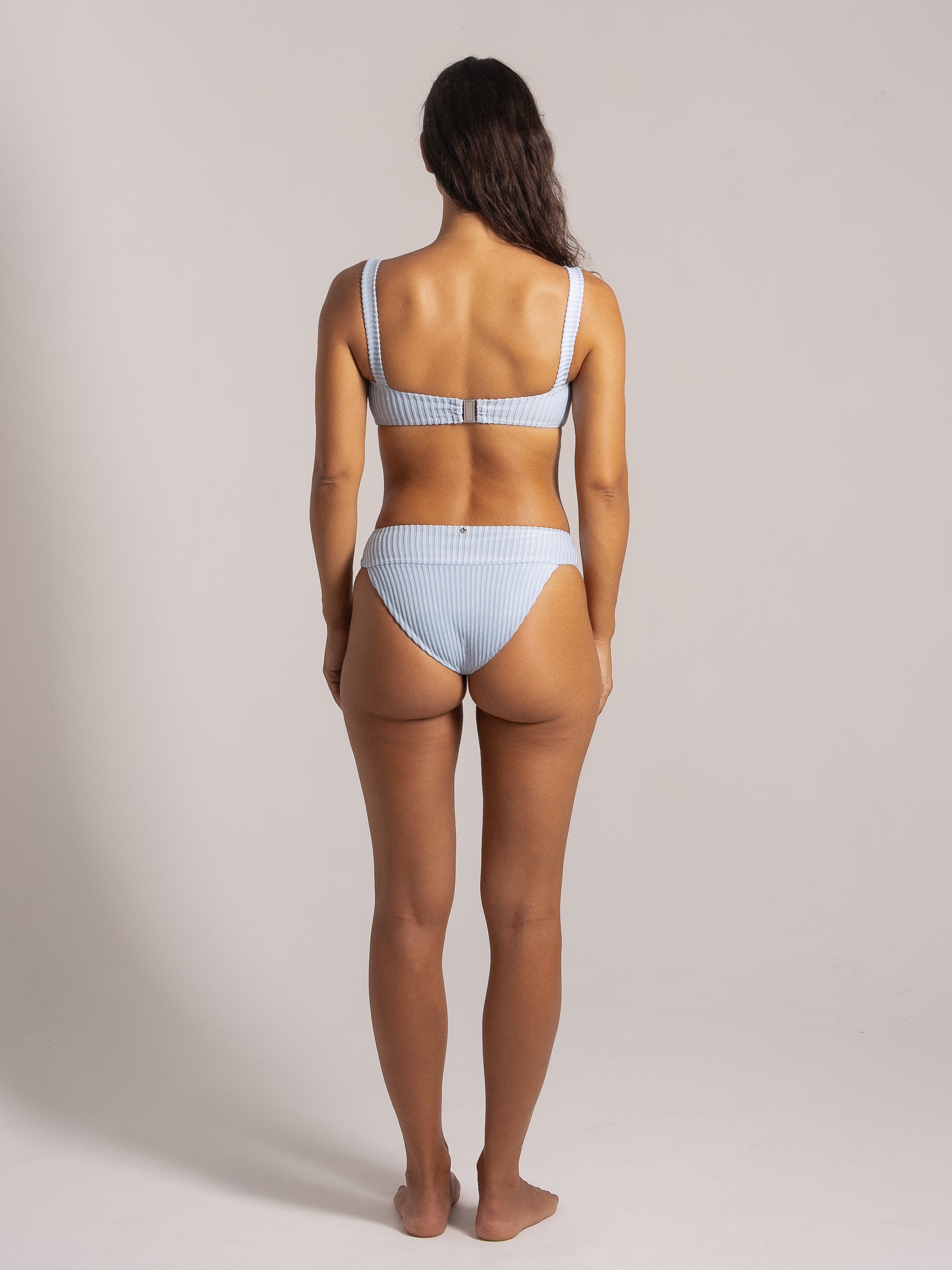 Back view of a light blue textured bikini set with wide straps and a high-waisted cheeky bottom.