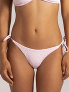 Front view of light pink textured string bikini bottom with side ties