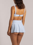 Back view of light blue textured swim skirt showing cheeky bikini bottom.