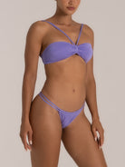 Three-quarter view of lilac shimmer bikini set with bandeau top and strappy bottom