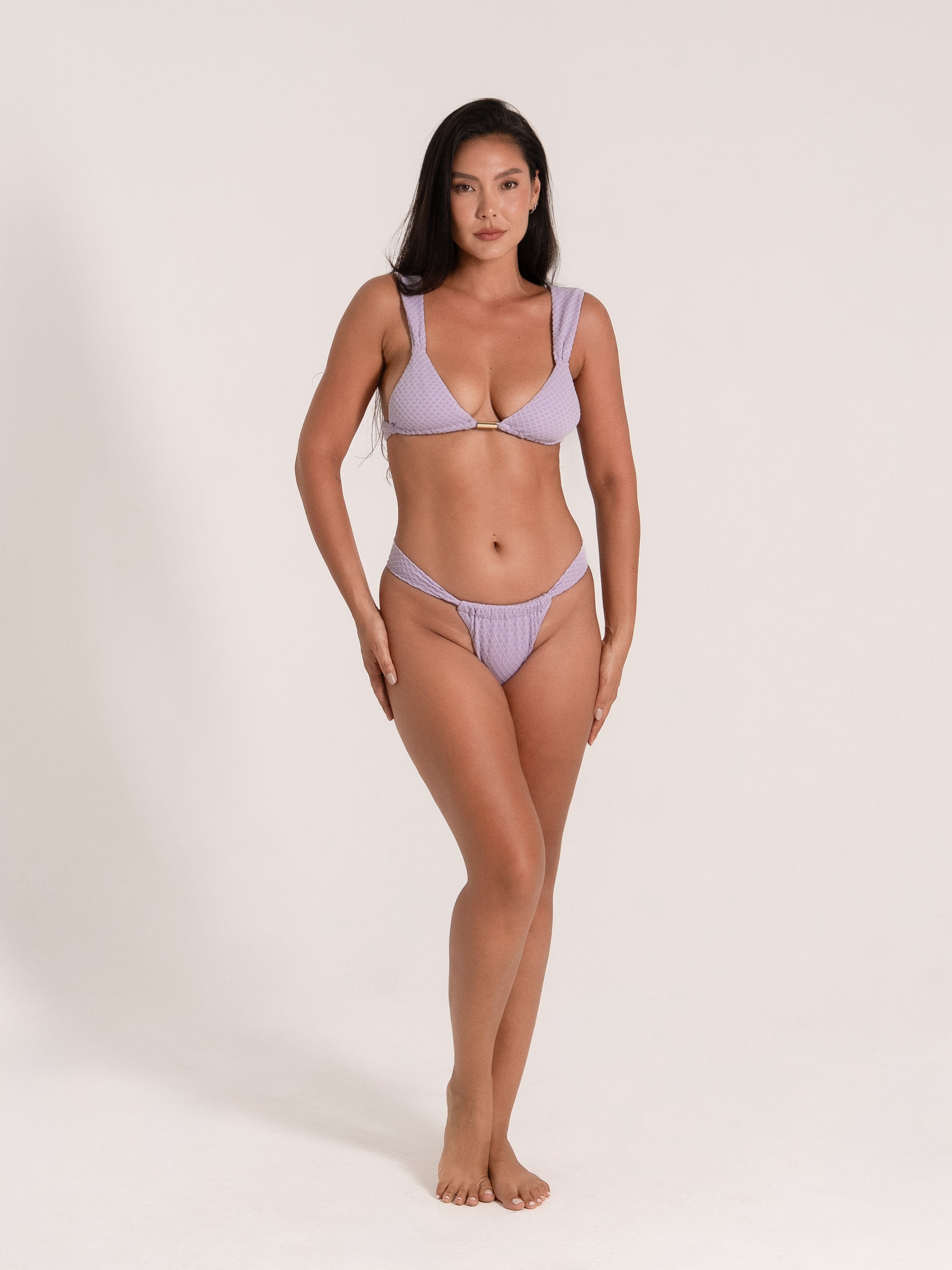 Woman wearing lilac bikini with ring detail and textured fabric