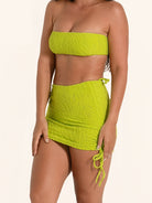 Lime green bikini skirt bottom featuring ruched sides and mini length.