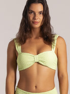 Close-up front view of lime green bikini top with wide straps and knot detailing
