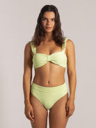 Lookbook style front shot of a lime green bikini top with center twist and textured fabric