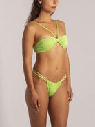 Side angle showing ruched shimmer bikini bottom in lime green