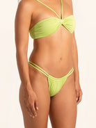 Lime green swim bottom featuring minimal cheeky coverage.