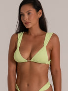 Close-up of a lime green textured bikini top with plunging neckline and metal center ring.