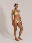 Side profile of model in lime textured triangle bikini set