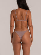 Back view of mauve bikini bottom with minimal coverage and textured finish
