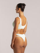 Rear angle of a mint green bikini top with deep scoop back and wide straps in textured finish