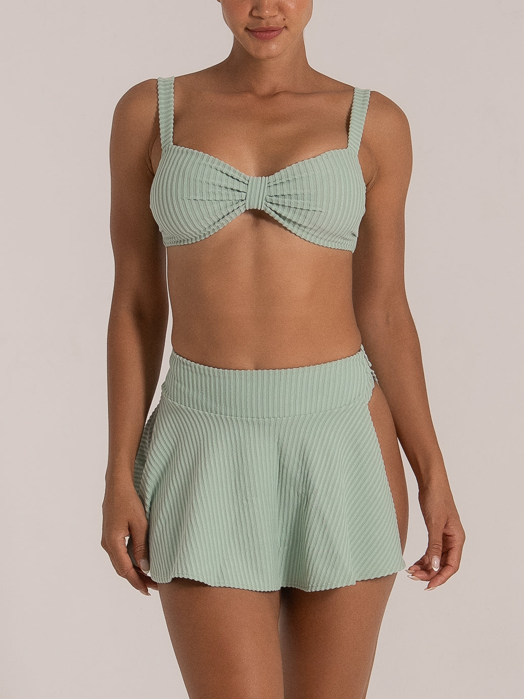 Mint green ribbed bikini cover-up skirt with high-waisted fit and side slits, front view.