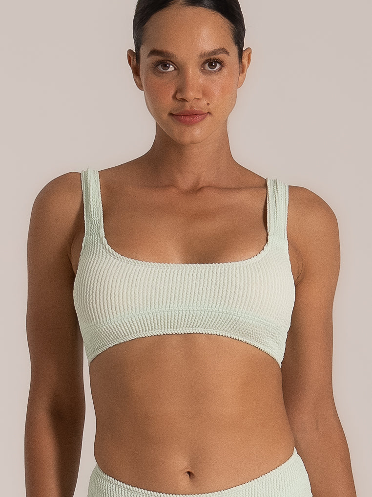 Close-up of mint green bikini top with square neckline and textured fabric