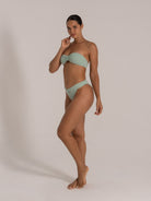 Front angled view of a strapless mint green bikini with ruched detailing and textured fabric.