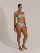 Side angle of mint green bandeau bikini set featuring a twist-front top and flattering V-cut bottoms.