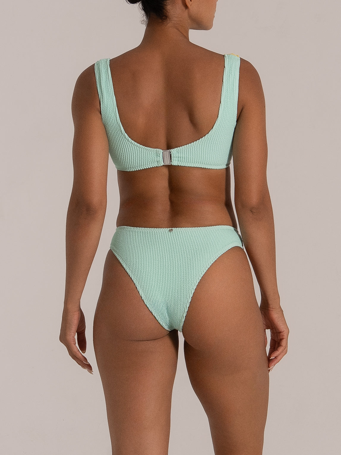 Back view of a mint green high-waisted bikini bottom with textured fabric