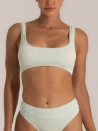 Front view of a woman wearing a mint green textured bikini set with a square neckline top and high-waisted bottoms, both featuring a waffle-knit fabric for added structure and comfort.